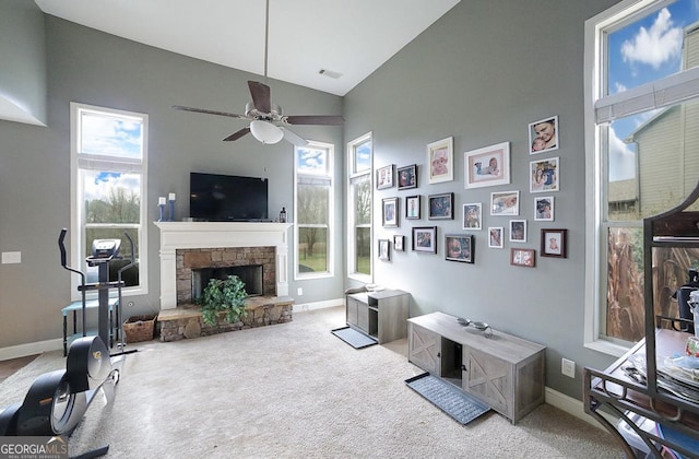 living room featuring a fireplace, plenty of natural light, light colored carpet, and ceiling fan