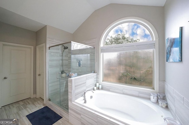 bathroom featuring lofted ceiling and plus walk in shower