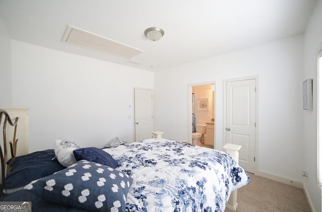 bedroom with connected bathroom and light colored carpet