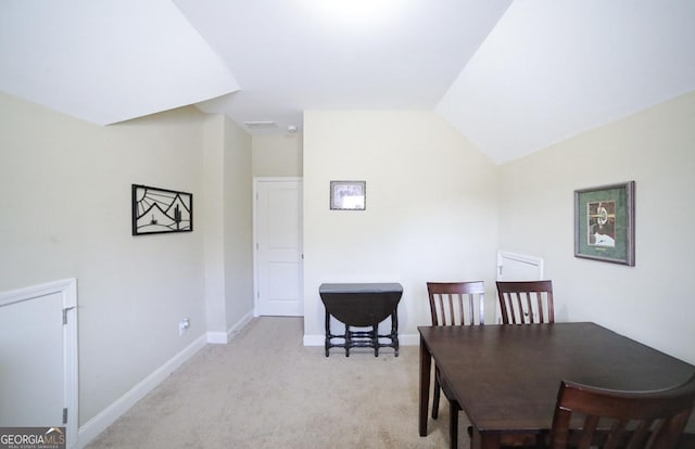 carpeted dining area featuring lofted ceiling