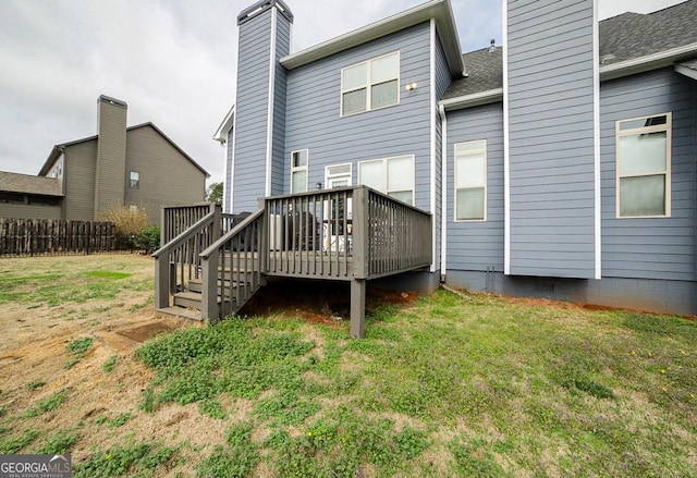 rear view of house with a deck and a yard