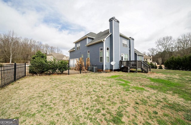 rear view of house with a yard and a wooden deck