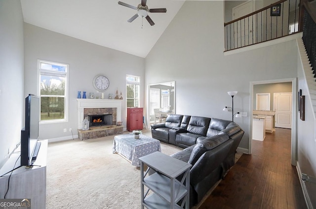 living room with high vaulted ceiling, ceiling fan, dark hardwood / wood-style floors, and a fireplace