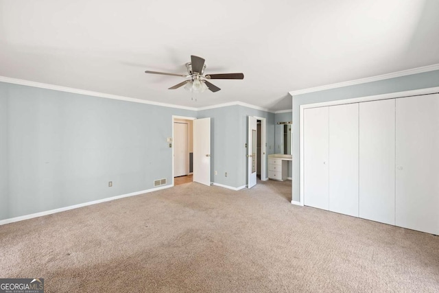 unfurnished bedroom featuring light carpet, ceiling fan, ensuite bathroom, and crown molding