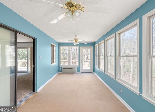 unfurnished sunroom featuring a wall mounted air conditioner