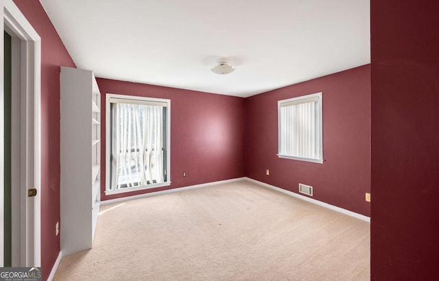 empty room with light carpet and a healthy amount of sunlight