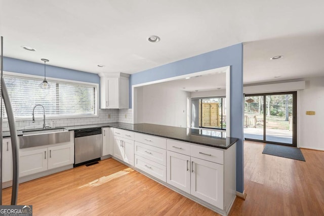 kitchen with stainless steel dishwasher, sink, white cabinetry, and light wood-type flooring