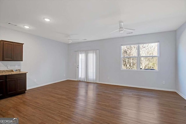 unfurnished living room with dark wood-type flooring and ceiling fan