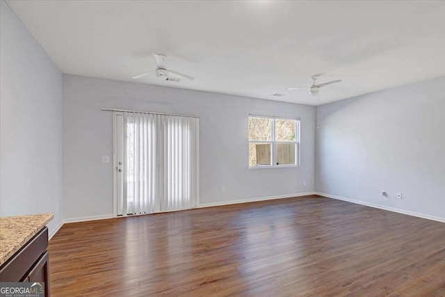 unfurnished living room with ceiling fan and dark wood-type flooring