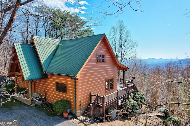 view of side of home with a deck with mountain view