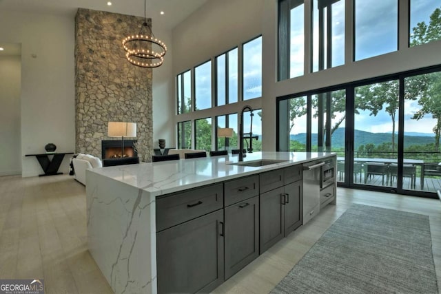 415 Green Ridge Trl, Blue Ridge, GA 30513 - kitchen featuring sink, a mountain view, a fireplace, an island with sink, and light stone countertops