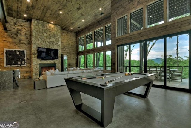 415 Green Ridge Trl, Blue Ridge, GA 30513 - game room with concrete flooring, a stone fireplace, and a towering ceiling