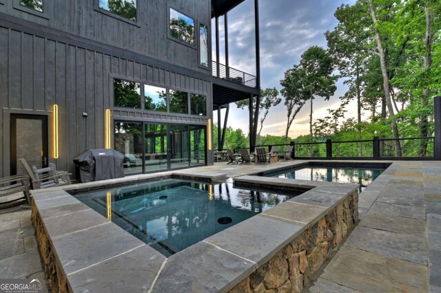 415 Green Ridge Trl, Blue Ridge, GA 30513 - pool at dusk with a patio, an in ground hot tub, and grilling area