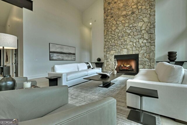 415 Green Ridge Trl, Blue Ridge, GA 30513 - living room featuring light wood-type flooring, a towering ceiling, and a fireplace