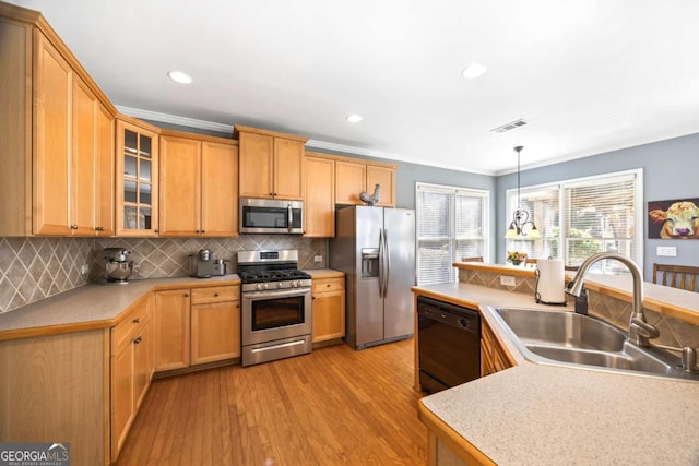 kitchen featuring light hardwood / wood-style flooring, sink, appliances with stainless steel finishes, decorative backsplash, and pendant lighting