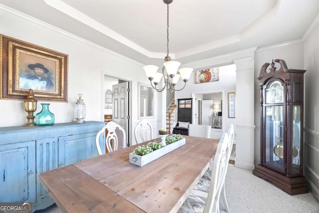 dining area with an inviting chandelier, decorative columns, crown molding, a raised ceiling, and light carpet