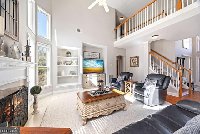 living room with ceiling fan and a high ceiling