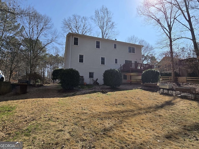 rear view of house with a yard and a deck