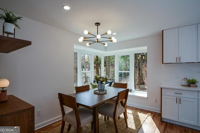 dining room featuring a healthy amount of sunlight, baseboards, a chandelier, and dark wood-type flooring