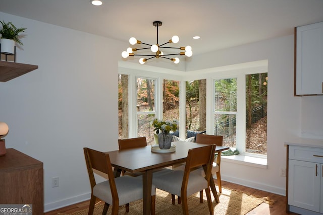 dining area featuring recessed lighting, dark wood-style flooring, a notable chandelier, and baseboards