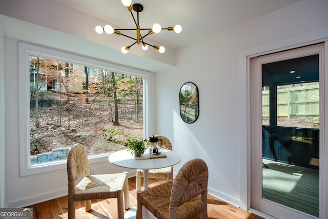 dining area featuring an inviting chandelier, baseboards, and wood finished floors