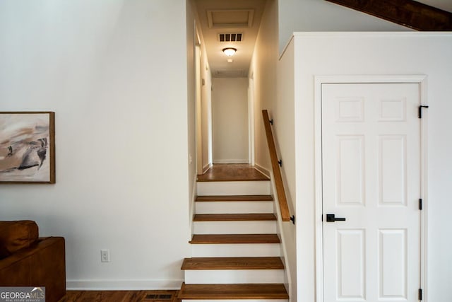 stairway featuring baseboards and visible vents