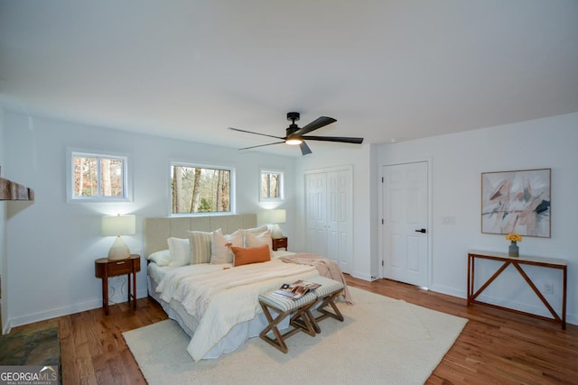 bedroom featuring wood finished floors, a ceiling fan, and baseboards