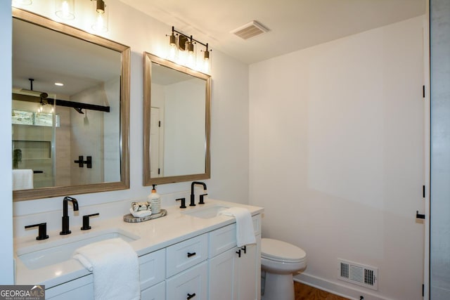 full bath with toilet, visible vents, and a sink