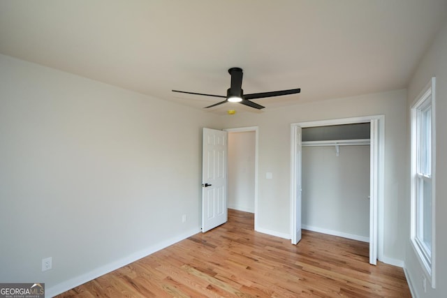 unfurnished bedroom featuring a ceiling fan, a closet, light wood-style flooring, and baseboards