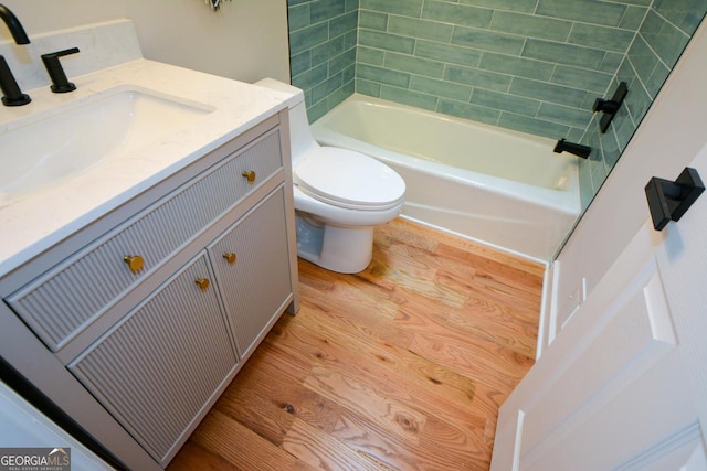 bathroom featuring washtub / shower combination, vanity, toilet, and wood finished floors