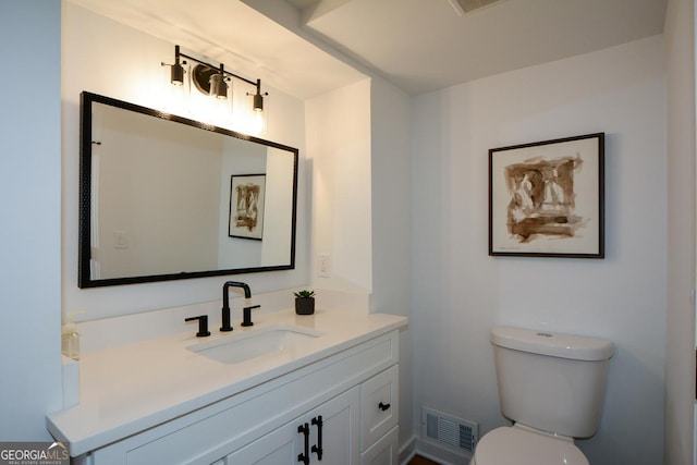 half bathroom featuring toilet, vanity, and visible vents