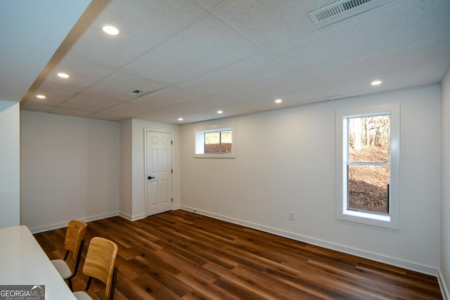 dining space featuring a paneled ceiling, dark wood finished floors, and baseboards