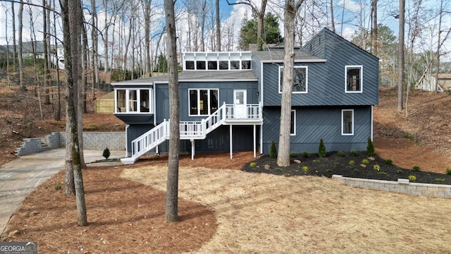 view of front facade with stairway and a sunroom