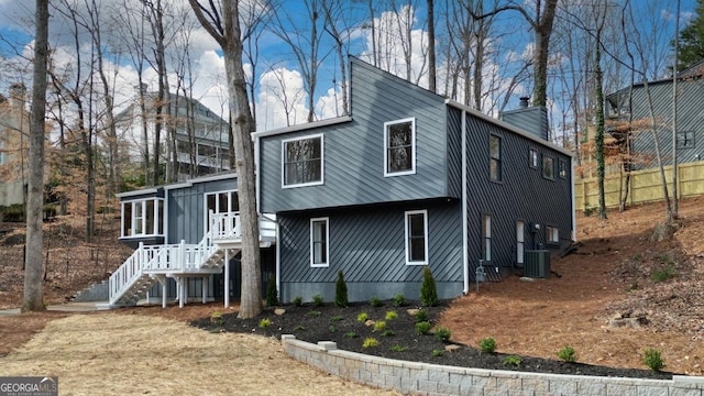 view of home's exterior with a sunroom, a chimney, and fence