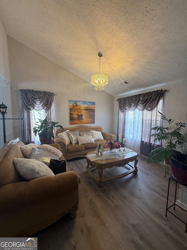 living room with hardwood / wood-style flooring, a chandelier, vaulted ceiling, and a textured ceiling