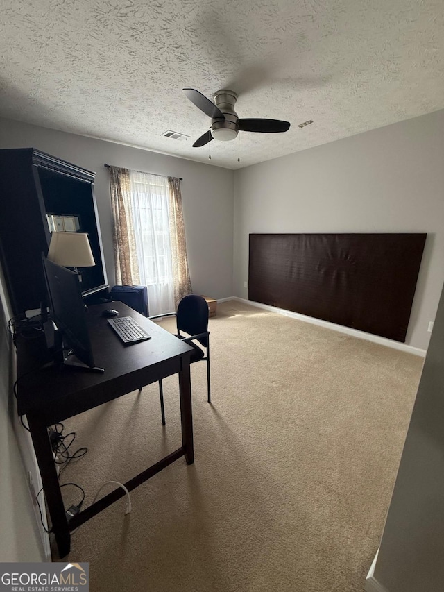 office area with ceiling fan, carpet flooring, and a textured ceiling