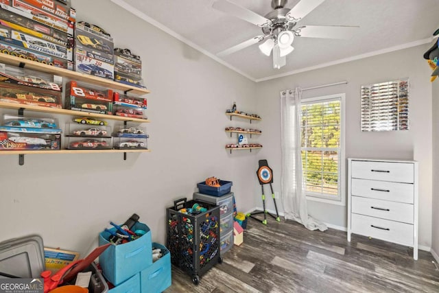 game room featuring ornamental molding, dark hardwood / wood-style floors, and ceiling fan