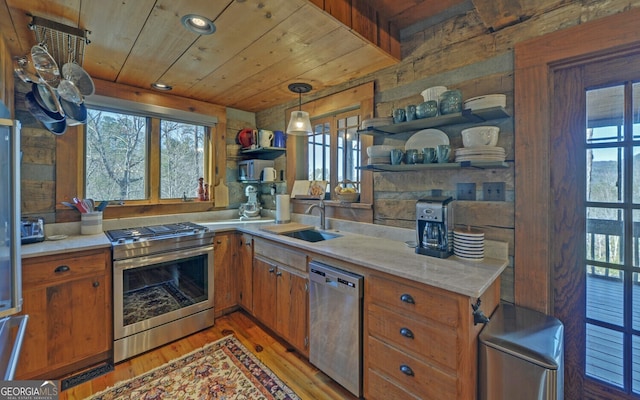 kitchen with sink, pendant lighting, light hardwood / wood-style floors, stainless steel appliances, and wooden ceiling