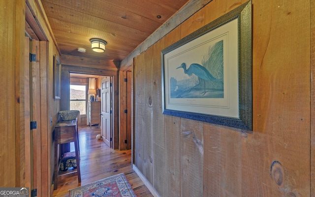 hallway featuring hardwood / wood-style floors, wooden walls, and wooden ceiling