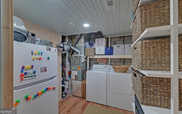 laundry room with light wood-type flooring, wooden ceiling, and separate washer and dryer