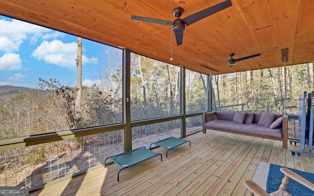 unfurnished sunroom featuring wooden ceiling and ceiling fan