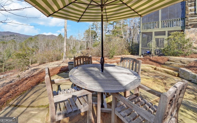 view of patio / terrace with a sunroom and a mountain view