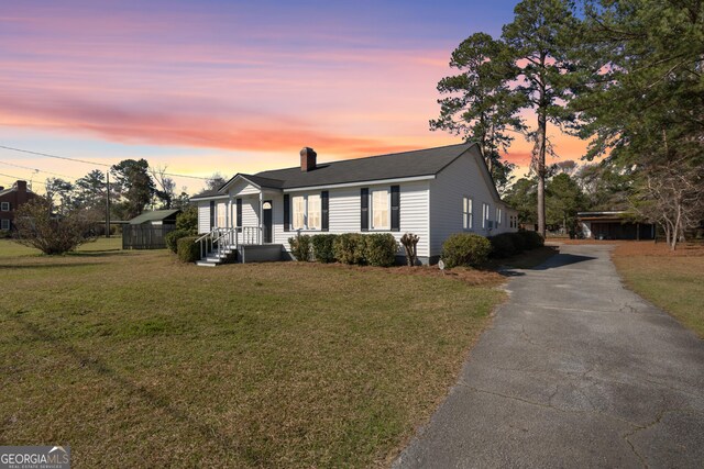 view of front of home with a chimney and a front lawn