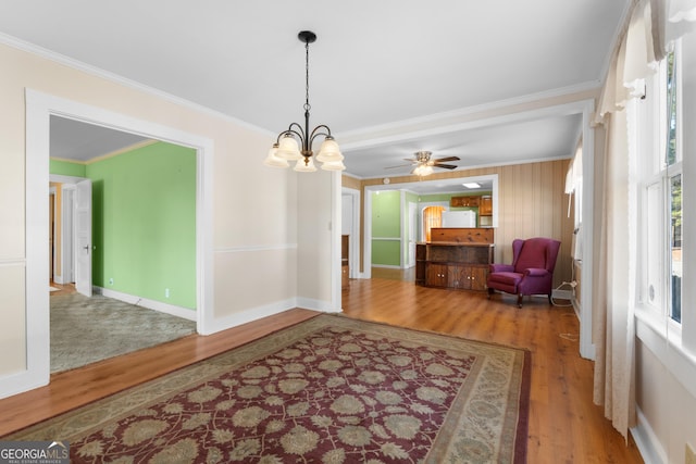 living area featuring a notable chandelier, crown molding, and wood finished floors