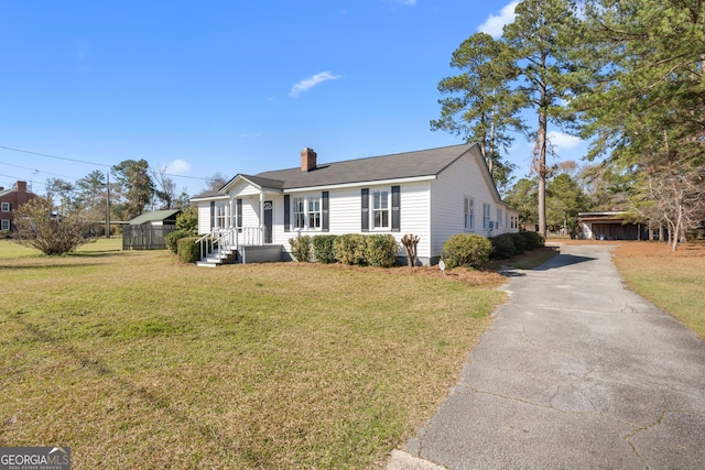 view of front of home featuring a front lawn and a chimney