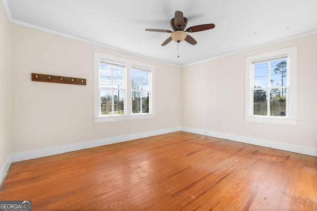 unfurnished room with baseboards, ornamental molding, and wood finished floors