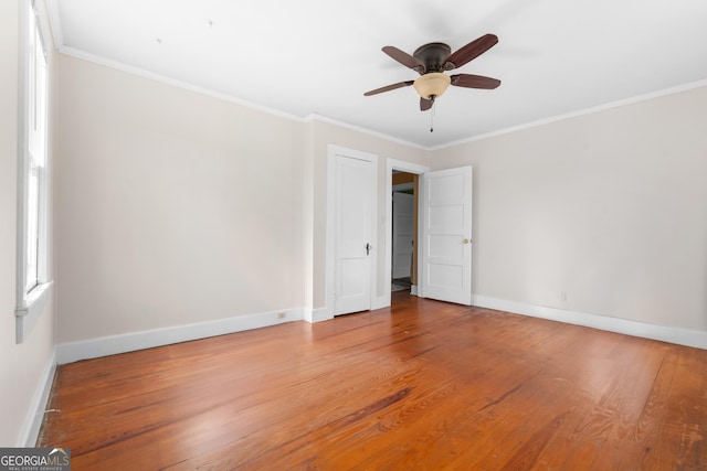 unfurnished bedroom featuring baseboards, ceiling fan, ornamental molding, and light wood-style floors