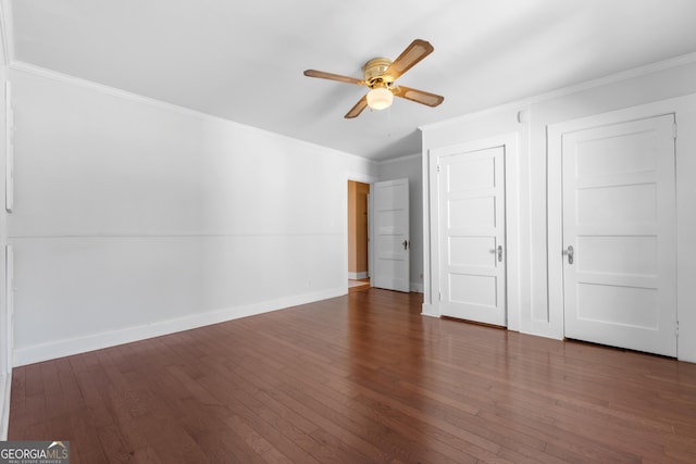 unfurnished bedroom featuring ornamental molding, dark wood finished floors, a ceiling fan, and baseboards