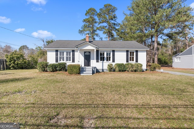 view of front of house featuring a chimney and a front yard