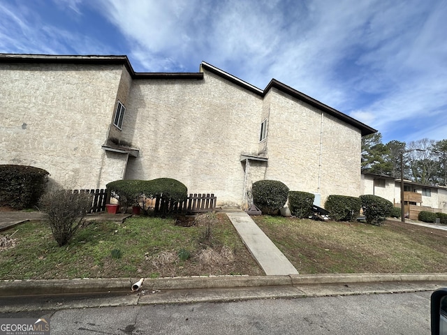 view of property exterior featuring a yard and stucco siding